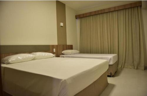 a room with two beds and a window at Praias do Lago in Caldas Novas