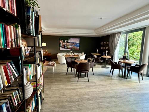 a library with tables and chairs and books at Hotel Alfieri in Sirmione