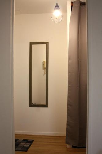 - un miroir mural dans une chambre avec une lampe dans l'établissement Appartement Spacieux Domont 25 min Paris, à Domont