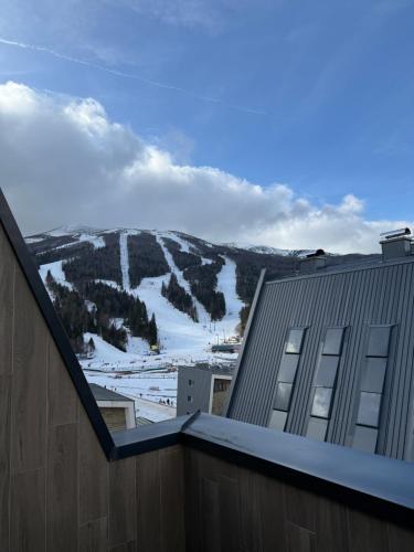 a view of a snowy mountain from a building at Ski & Relax Apartment Bjelašnica in Bjelašnica