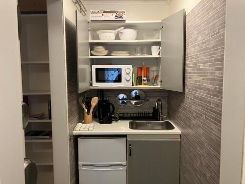 a small kitchen with a sink and a microwave at Lugnåsberget Ekohotell in Mariestad