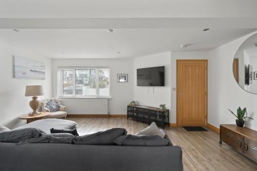 a living room with a couch and a tv at Ranalegh Court in Saint Columb Minor