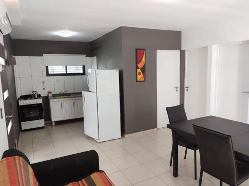 a kitchen with a table and a white refrigerator at Pauvalén Departamentos in Potrero de los Funes