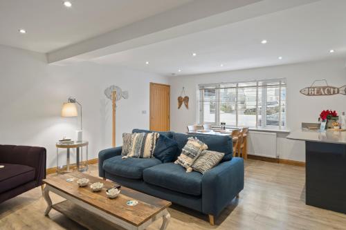 a living room with a blue couch and a table at Ranalegh Court in Saint Columb Minor