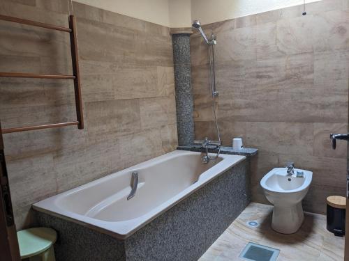 une salle de bain avec baignoire et toilettes dans l'établissement Maison au coeur de la forêt dans le Sidobre - GR36, à Lacrouzette