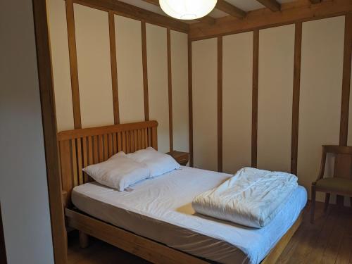 un lit avec un cadre en bois dans une chambre dans l'établissement Maison au coeur de la forêt dans le Sidobre - GR36, à Lacrouzette