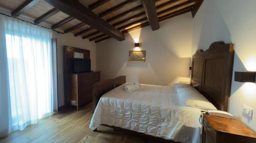 a bedroom with a large bed and a television at Agriturismo Colli Martani in Massa Martana