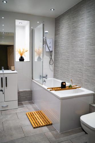 a bathroom with a large tub and a sink at 20min train to Edinburgh, The Coorie Inn in Inverkeithing