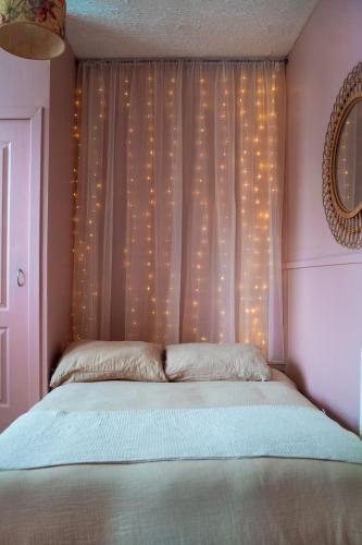 a bedroom with a bed with a window with lights at 20min train to Edinburgh, The Coorie Inn in Inverkeithing