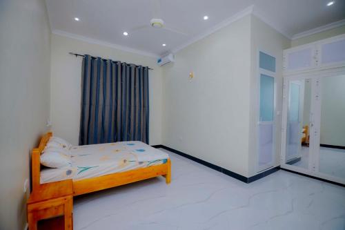 Un dormitorio con una cama en una habitación con ventana. en Zanzibar home Residence, en Zanzíbar