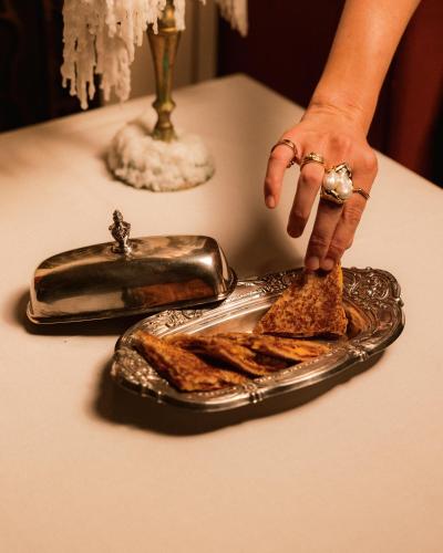 a person is reaching for a plate of toast at Hotel Rochechouart - Orso Hotels in Paris