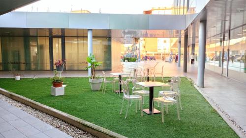 a group of tables and chairs on grass in a building at Blue Shades Hotel in Pisa