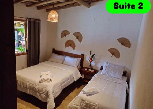 twee bedden in een slaapkamer met parasols aan de muur bij Rancho Bela Vista Sapirara in Trancoso