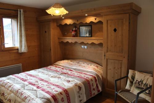 une chambre avec un lit dans une cabane en rondins dans l'établissement Chardons Argentés, à Samoëns