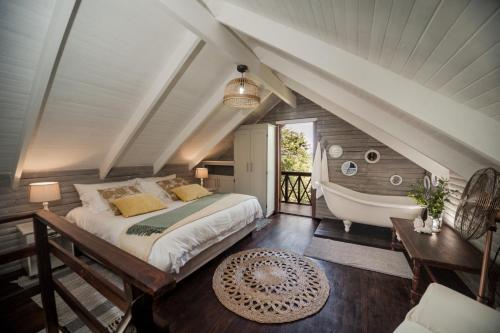 una camera da letto con un letto grande e una vasca da bagno di Viewpoint Estate Accommodation a Haenertsburg