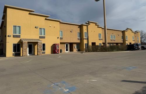 an empty parking lot in front of a building at West Worth Inn & Suites White Settlement in White Settlement