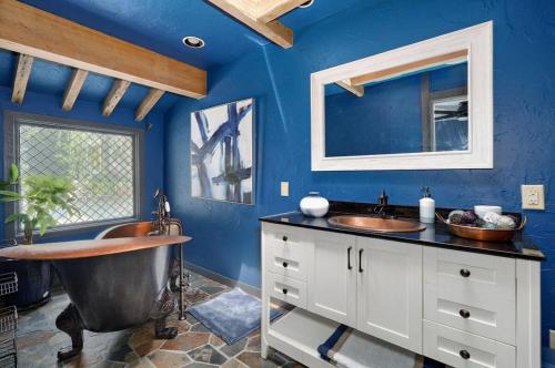 a blue bathroom with two sinks and a tub at The African Queen in Springfield