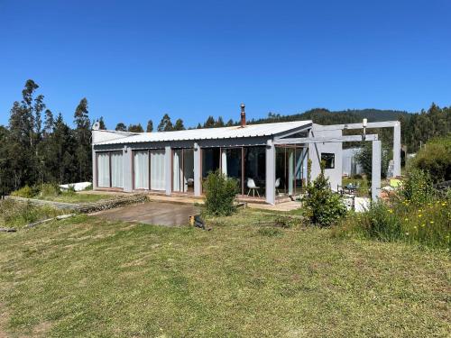 a large white house with a lot of windows at Casa de campo in De Cauquenes