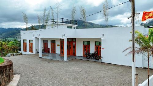 a white building with a motorcycle parked in it at Tea Hills Lake in Hatton