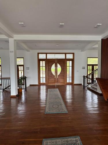 a large room with a wooden floor and a large door at Tea Hills Lake in Hatton