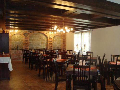 um restaurante com mesas e cadeiras de madeira numa sala em Pension Casa Iurca em Sighetu Marmaţiei