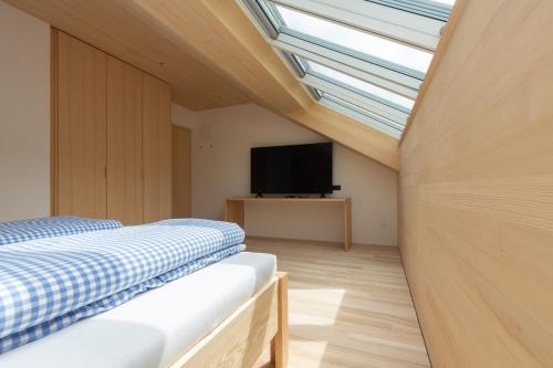 a bedroom with a bed and a flat screen tv at Beerenhus in Au im Bregenzerwald