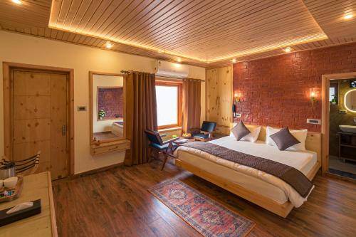 a bedroom with a large bed and a brick wall at PalPenzy - Bespoke Premium Stay in Srinagar