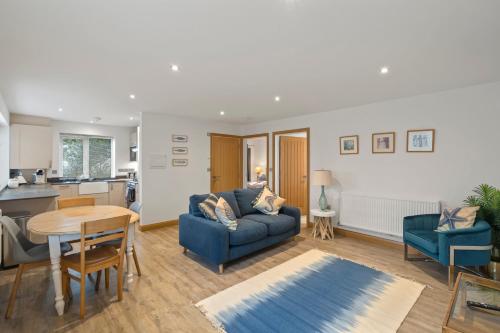 a living room with a blue couch and a table at Ranalegh Court in Saint Columb Minor