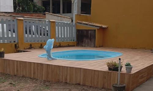 a swimming pool with a statue in a backyard at casa Amarela in Tamoios
