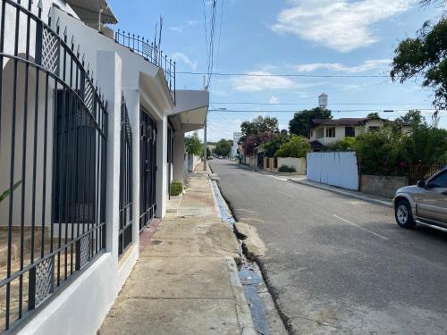 an empty street with a car parked on the side of a building at Alojamiento el Reloj primer nivel in San Fernando de Monte Cristi