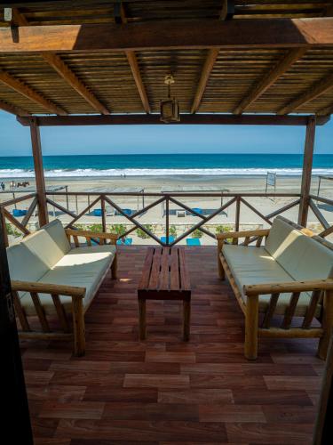 a balcony with chairs and a table and the beach at El Refugio de Vichayito in Vichayito