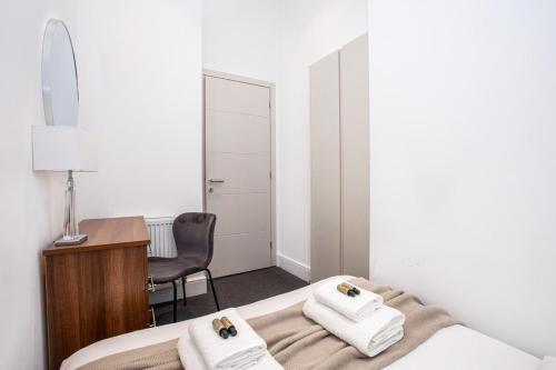 a bedroom with a bed and a desk and a chair at Harley Street Luxury Apartments by City Relay in London