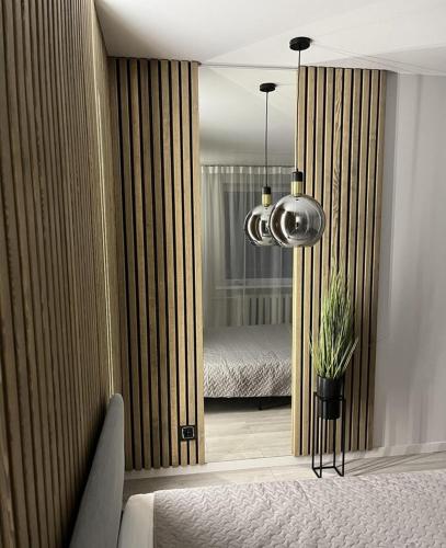 a bedroom with a bed and a large mirror at LUX Apartamentai in Marijampolė