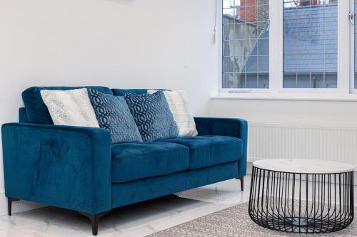 a blue couch in a living room with a table at Harley Street Luxury Apartments by City Relay in London