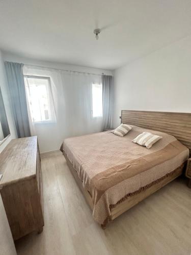 a bedroom with a large bed and two windows at Caribbean Dream Condo AC WIFI in La Laguna