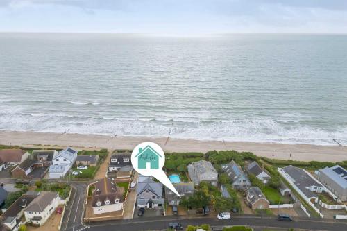 an aerial view of a house and the beach at Beachfront House w Pool & Steam in West Wittering