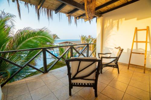 a balcony with two chairs and a view of the ocean at El Refugio de Vichayito in Vichayito