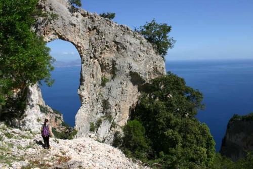 a person standing on top of a rocky mountain at B&B Sa Clarera in Baunei