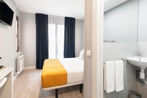 una habitación de hotel con una cama y un lavabo en 8Rooms Madrid, en Madrid