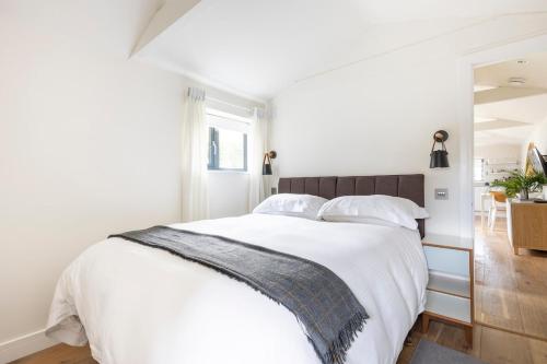 a white bedroom with a large bed with white sheets at Self contained 1 bed house v near centre, parking in Bath