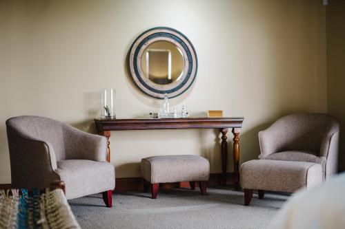 a room with two chairs and a mirror on the wall at Hitgeheim Country Lodge in Addo