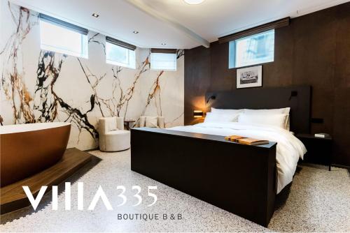 a bedroom with a large bed and windows at Villa335 boutique b&b in Amsterdam