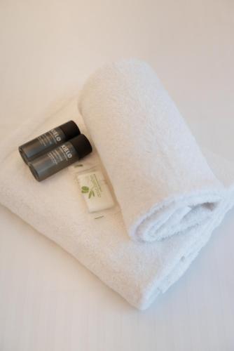 - une serviette blanche avec une bouteille de rouge à lèvres dans l'établissement Moderne et Chic T3, à deux pas de la Croisette, à Cannes