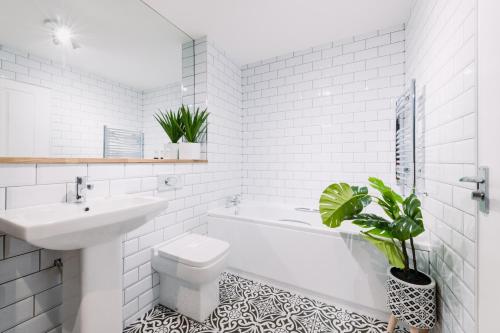 a bathroom with a sink and a toilet and a bath tub at ComfySleep Apartments in Glasgow