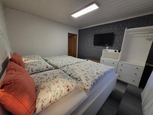 a bedroom with a bed and a dresser and a television at Fewo Weidenhof in Großschwabhausen