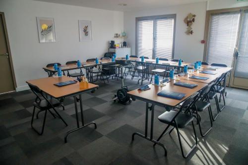 a classroom with rows of tables and chairs at Campanile Montargis - Amilly in Amilly