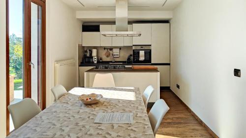 a dining room with a table and chairs and a kitchen at La dimora delle Rose in Passignano sul Trasimeno