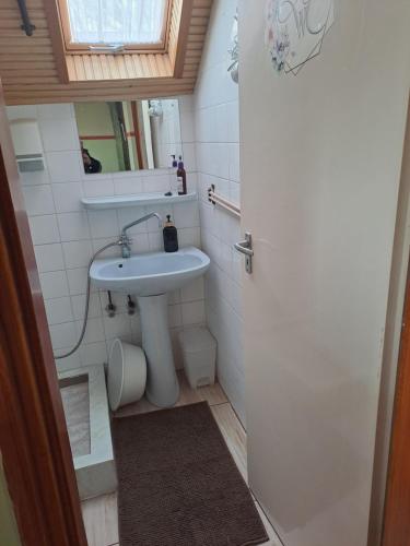 a small bathroom with a sink and a mirror at BALATONHEGYVIDÉKI APARTMAN in Balatonederics