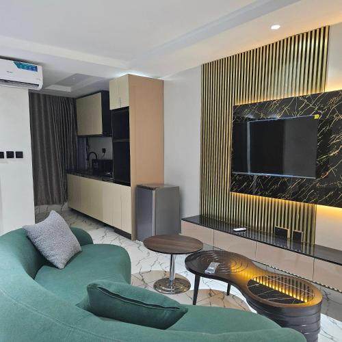 a living room with a couch and a tv at Anibex Luxe Apartment in Abuja