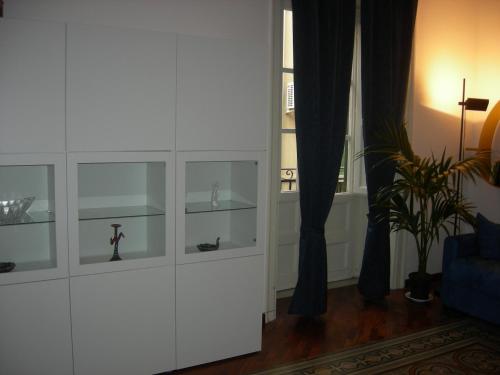 un armario blanco con estanterías de cristal en la sala de estar en I Pupi Di Belfiore, en Palermo